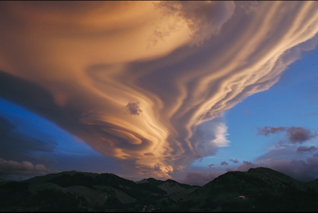 Stacked lenticular wave clouds at sunset
