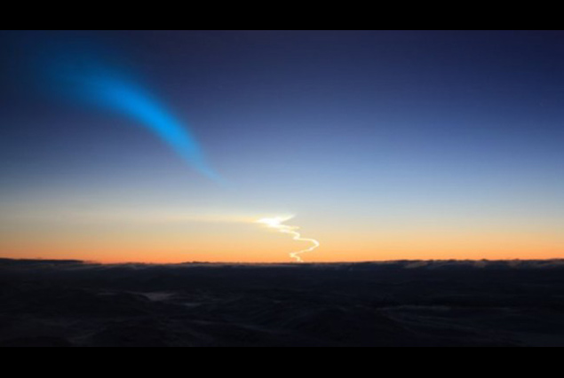 Twilight missile launch trail with corkscrew exhaust and blue cone plume